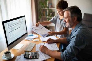 padre e figlio consultano uno schermo del pc