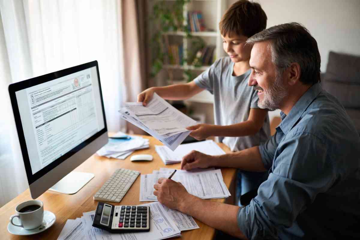 padre e figlio consultano uno schermo del pc
