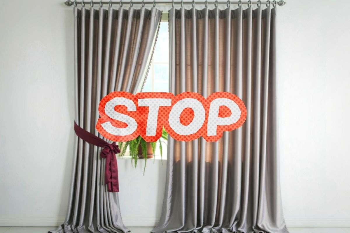 scritta stop su una finestra con la tenda