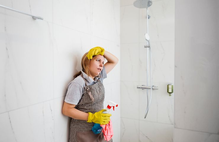 donna stanca di pulire il box doccia 