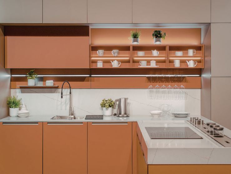 cucina angolare moderna di colore terracotta con pensili, piano cottura e lavello