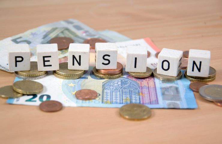 soldi in contanti e spiccioli e dadi con scritta pensione