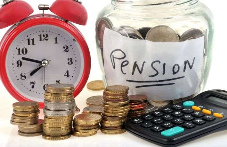 barattolo di vetro con scritta pensione e spiccioli, calcolatrice e orologio