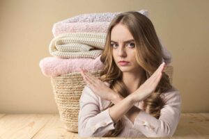 asciugamani e donna che fa segno no con la mano