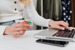 donna con carta di credito in mano che sta al pc