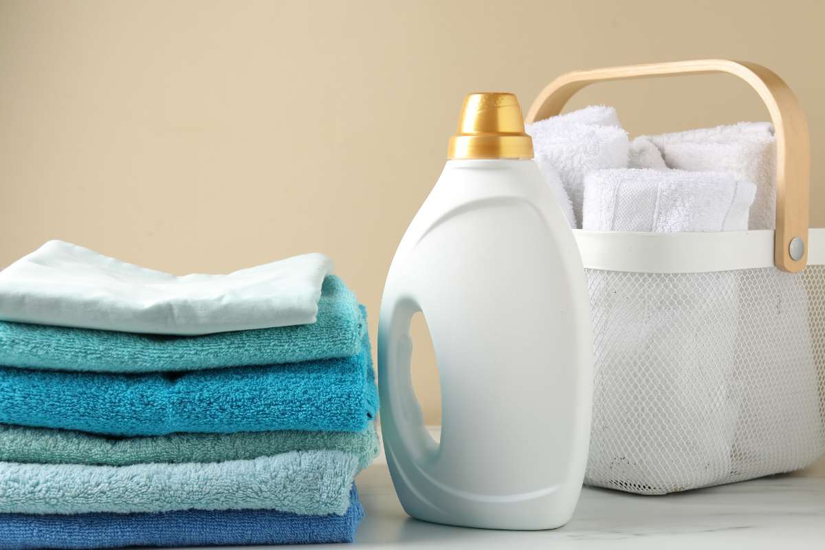 asciugamani piegati e detersivo vicino 