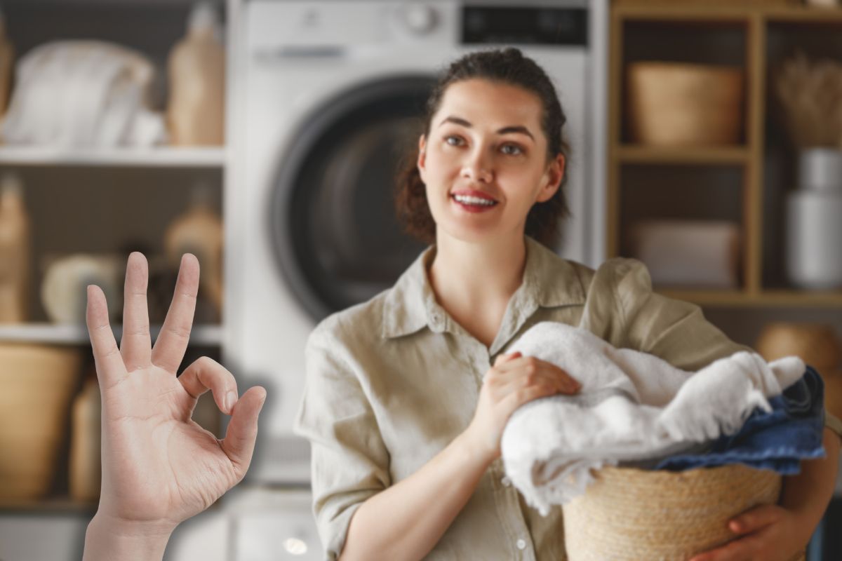 donna con cesta di bucato in mano e mano che fa ok