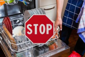 sfondo di una lavastoviglie carica e un cartello stop