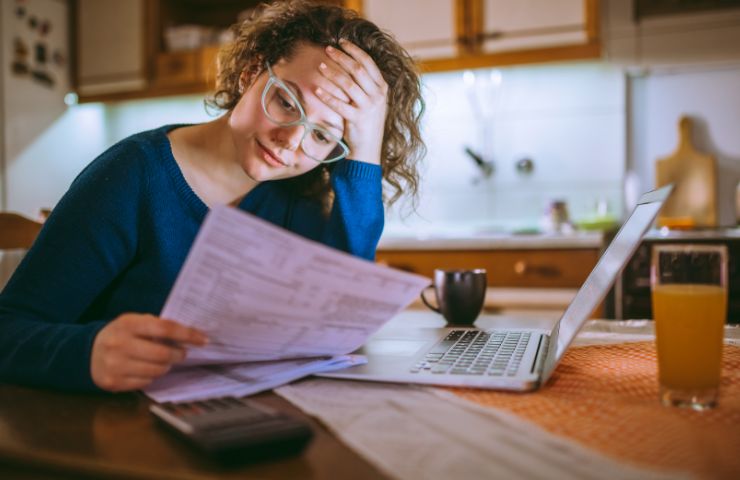 donna disperata mentre legge bollette